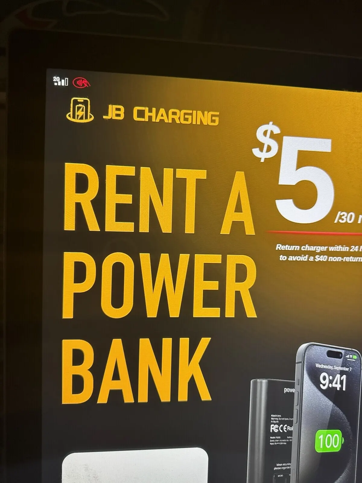 Close-up of a station screen reading Rent a Power Bank, $5 per 30 minutes, with a partly visible line telling renters to return the charger within 24 hours to avoid a $40 non-return fee